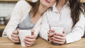 close-up-lesbian-woman-s-hand-holding-cup-coffee-table