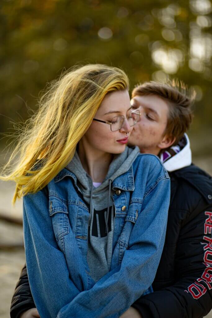 queer γυναίκες κάθονται αγκαλιασμένες η μία πίσω από την άλλη και ζουν τρυφερές στιγμές σε υπαίθριο χώρο